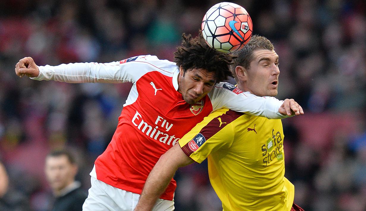 Pemain Arsenal, Mohamed Elneny (kiri) berebut bola dengan pemain Burnley, Sam Vokes dalam putaran keempat Piala FA di Stadion Emirates, London, (30/1/2016). (AFP/Glyn Kirk)