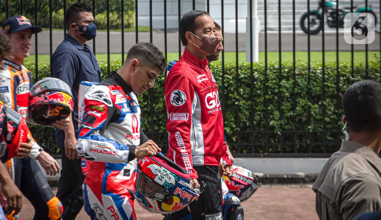 Presiden Joko Widodo berjalan bersama para pembalap MotoGP keluar dari Istana Merdeka, Jakarta Pusat, Rabu (16/3/2022). Jokowi melepas iring-iringan pembalap berkeliling di jalan utama ibu kota sebelum para pembalap berlaga di MotoGP Mandalika yang berlangsung pekan ini. (Liputan6.com/Faizal Fanani)