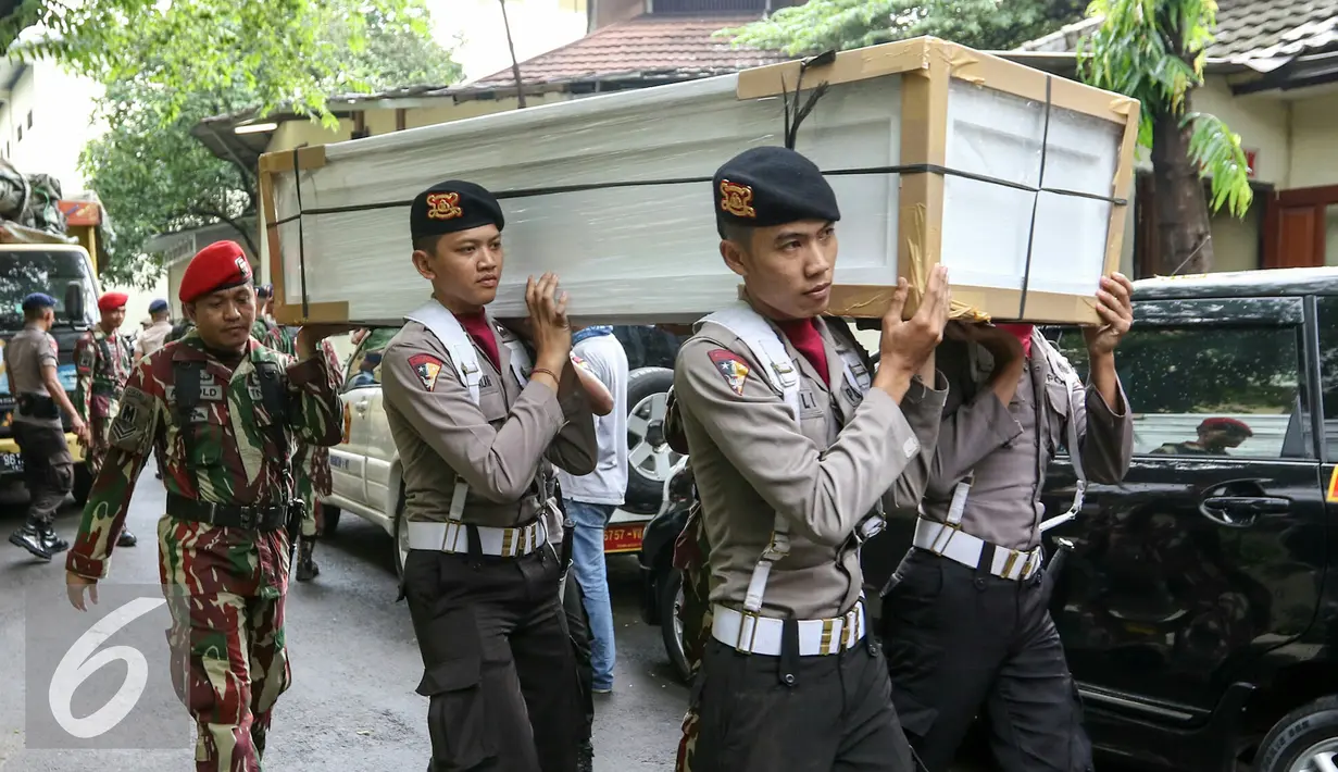 Petugas mengangkat  peti ke ruang transit jenazah yang dipersiapkan untuk korban helikopter TNI yang jatuh di RS Polri, Jakarta, Senin (21/3). Helikopter TNI AD mengalami kecelakaan saat akan mendarat di stadion Poso. (Liputan6.com/Yoppy Renato)