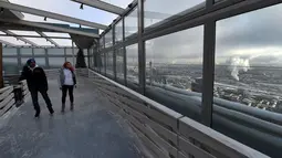 Keseruan pengunjung bermain ice skating di arena ski lantai teratas pusat bisnis Oko Tower di Moskow, Rusia, Kamis (15/12). Arena ski yang berada di ketinggian 354 meter ini diklaim menjadi yang tertinggi di Eropa. (VASILY MAXIMOV/AFP)