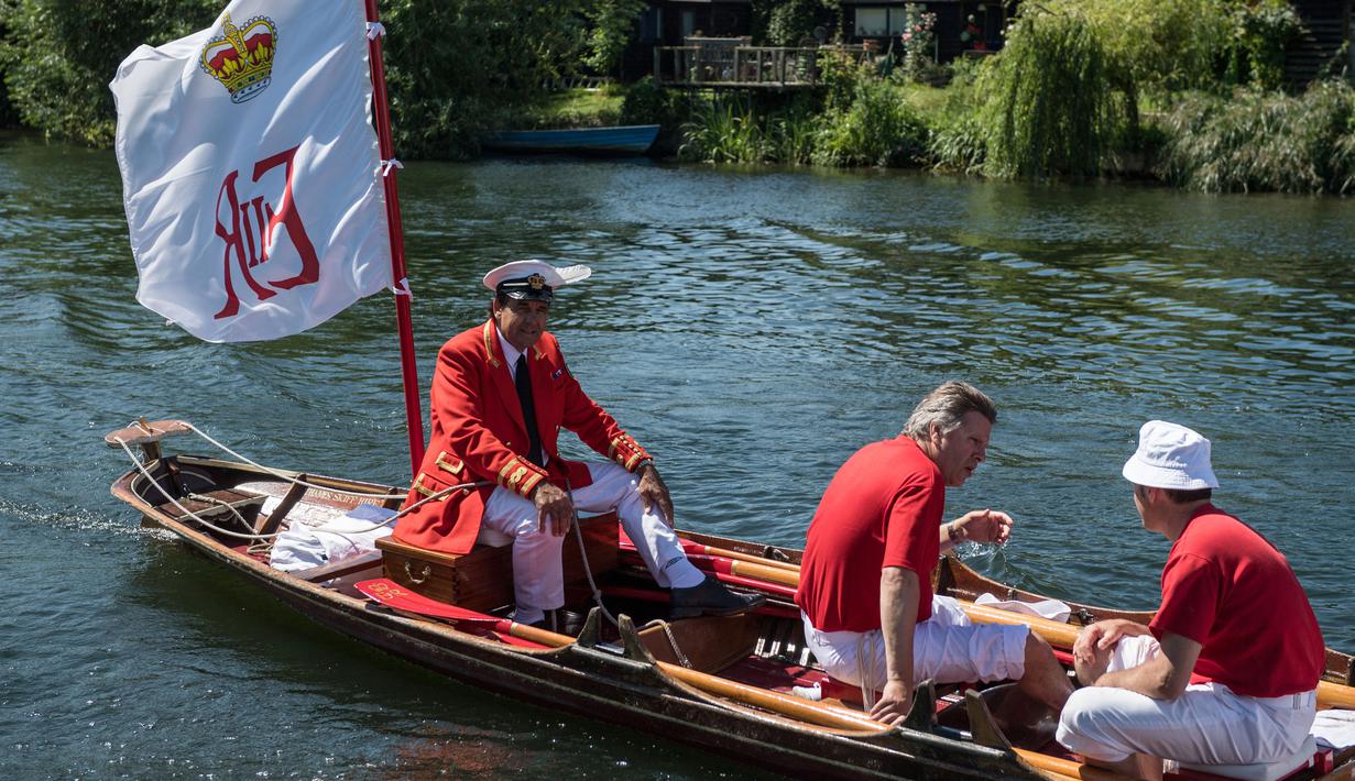 Petugas Penanda Angsa (Swan Marker) menyusuri Sungai Themes selama kegiatan Sawn Upping di dekat Shepperton, Inggris, Senin (17/7). Dari atas kapal berbendera, tim sensus mencari angsa-angsa yang sedang berenang untuk ditangkap. (CHRIS J RATCLIFFE / AFP)