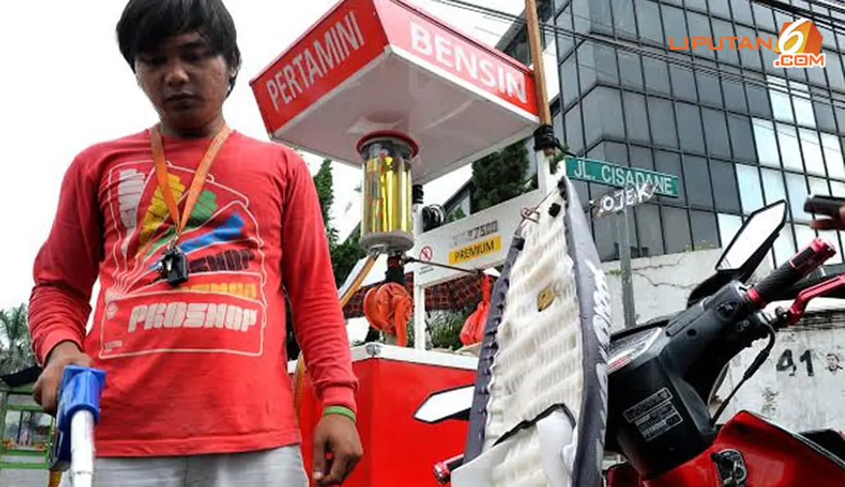 Penjual tampak mengisi tabung bensin yang akan dipakai saat ada pembeli (Liputan6.com/Johan Tallo).
