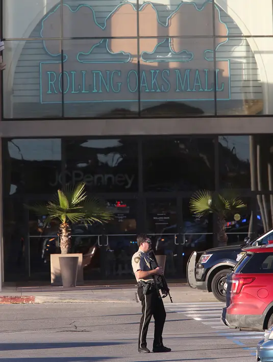 Polisi bersenjata berjaga di luar Rolling Oaks Mall, San Antonio, Texas, setelah terjadinya baku tembak, Minggu (22/1). Satu dari dua pengunjung yang mencoba menggagalkan aksi perampokan toko perhiasan, tewas ditembak pelaku perampokan. (AP Photo)