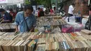 Seorang pria mencari buku selama pameran buku bekas di Hanoi, Vietnam  (26/10).( AFP Photo/Hoang Dinh Nam)