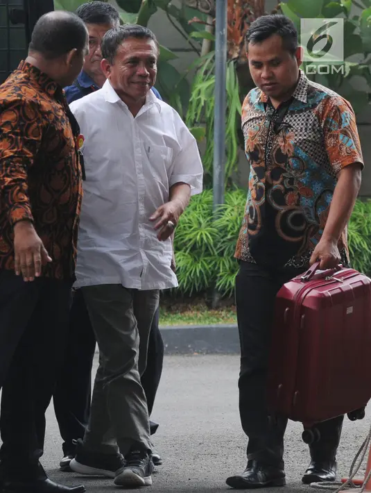 Gubernur Aceh Irwandi Yusuf didampingi petugas tiba di Gedung KPK, Jakarta, Rabu (4/7). Irwandi yang menumpang mobil tahanan KPK sebelumnya menjalani pemeriksaan di Markas Polda Aceh selama lebih dari 10 jam. (Merdeka.com/Dwi Narwoko)