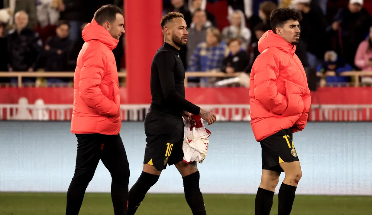 Striker PSG, Neymar (tengah) dan rekannya Vitinha (kanan) berjalan meninggalkan lapangan setelah kalah 1-3 dari AS Monaco dalam laga Liga Prancis 2022/2023 di Louis II Stadium, Monaco (11/2/2023). Neymar sempat menegur dua rekannya, Hugo Ekitike dan Vitinha usai laga di ruang ganti yang dinilai tampil tak sesuai harapan. (AFP/Valery Hache)