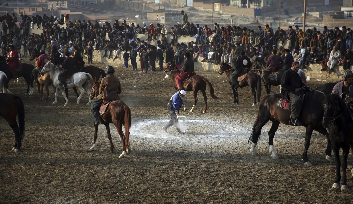 Seorang pria (tengah) membuat lingkaran saat pertandingan persahabatan buzkashi di pinggiran Kabul, Afghanistan, Jumat (27/12/2019). Buzkashi adalah olahraga tradisional Afghanistan di mana para pemainnya berlomba untuk menempatkan bangkai kambing ke dalam lingkaran. (AP Photo/Rahmat Gul)