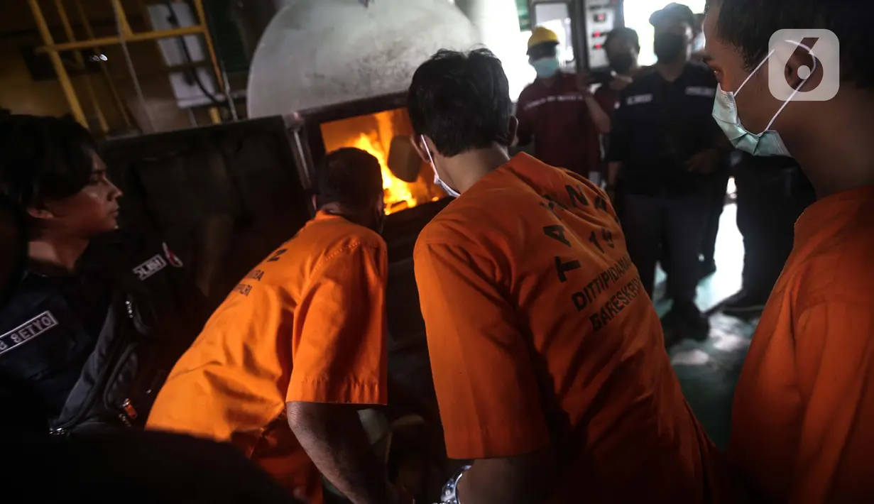 Tersangka memusnahkan barang bukti narkotika di Jakarta, Rabu (24/8/2022). Sebanyak 8.742,2 gram sabu, 295.363 gram ganja, serta 29.083 butir pil ekstasi dimusnahkan dalam pemusnahan ini. (Liputan6.com/Faizal Fanani)