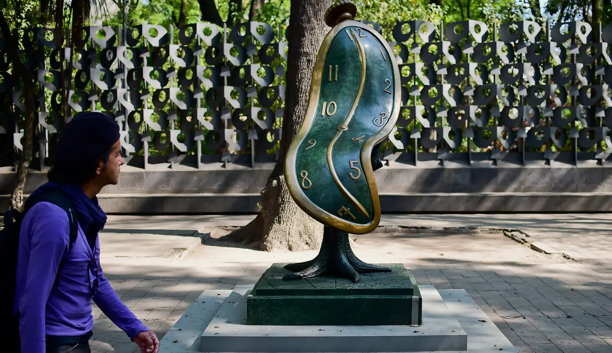 Seorang pria melihat patung " Dance of Time I " saat pameran "Salvador Dali: Urban Dreams" di Mexico City, Selasa (14/3). Patung-patung tersebut adalah karya seniman asal spanyol yang bernama Salvador Dali. (AFP PHOTO / RONALDO SCHEMIDT)