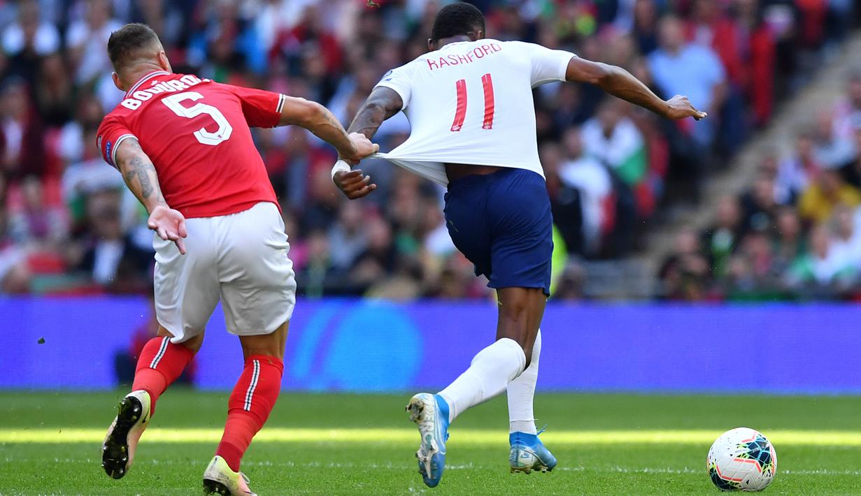 Bek Bulgaria, Nikolay Bodurov, menarik baju dari striker Inggris, Marcus Rashford, pada laga Kualifikasi Piala Eropa 2020 di Stadion Wembley, London, Sabtu (7/9). Inggris menang 4-0 atas Bulgaria. (AFP/Ben Stansall)