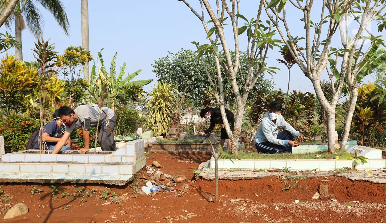 Pelanggar PSBB dihukum membersihkan makam di kawasan Stadion Pakansari, Kabupaten Bogor, Minggu (6/9/2020). Pemkab Bogor menghukum pelanggar PSBB dengan denda Rp 100 ribu serta sanksi sosial seperti membersihkan area makam, push up, dan mempraktikkan prosesi pemakaman. (Liputan6.com/Herman Zakharia)