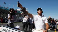 Pembalap dari tim Mercedes, Lewis Hamilton mengikuti parade jelang balapan pertama musim ini di GP F1 Australia di Melbourne, Australia, (25/3). Hamilton menempati posisi start terdepan dalam Grand Prix Australia. (AP Photo/Asanka Brendon Ratnayake)