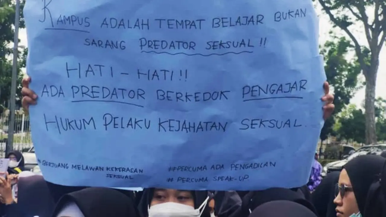 Salah seorang mahasiswi membawa kertas bertuliskan protes terhadap vonis bebas terdakwa pencabulan mahasiswi Universitas Riau.