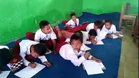 siswa SDN Pasir Kupa 2, Lebak, belajar beralaskan terpal dan menumpang di sebuah madrasah yang sama-sama berada di Desa Pasir Kupa, Kecamatan Kalanganyar, Kabupaten Lebak, Banten. (Liputan6.com/ Yandhi Deslatama)