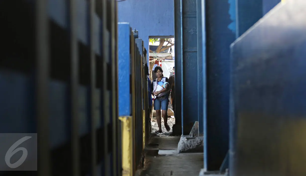 Warga melintasi jalan setapak di pintu air Petamburan, Jakarta, Jumat (17/2). Warga terpaksa melewati pintu air karena tidak ada jembatan penyeberangan orang di kawasan tersebut. (Liputan6.com/Immanuel Antonius)