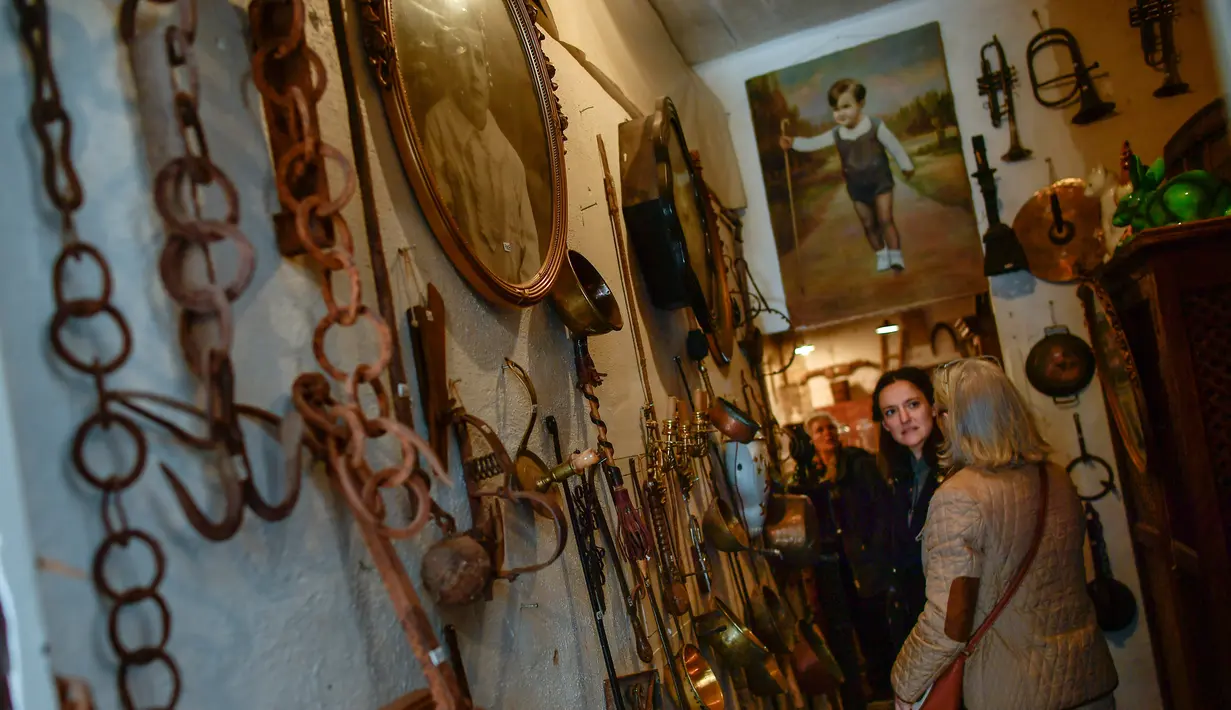 Sejumlah pengunjung melihat barang antik yang dipajang di toko milik Manuel Mosquera di "Pulgas' Market'' di Pamplona, Spanyol utara, (2/3). (AP Photo/Alvaro Barrientos)
