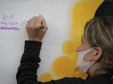 Seorang wanita menulis pesan di dinding dalam peringatan mengenang korban overdosis di Vancouver, Kanada (31/8/2020). Warga ambil bagian dalam acara peringatan di Vancouver untuk mengenang orang terkasih yang meninggal akibat overdosis dalam Hari Kesadaran Overdosis Internasional. (Xinhua/Liang Sen)