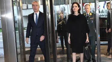 Sekretaris Jenderal NATO Jens Stoltenberg (kiri) menyambut aktris dan Duta UNHCR, Angelina Jolie saat  tiba di Markas Besar NATO di Brussels, Belgia (31/1). Angelina Jolie tampil cantik dengan busana dan sepatu warna hitam. (AFP Photo/Emmanuel Dunand)