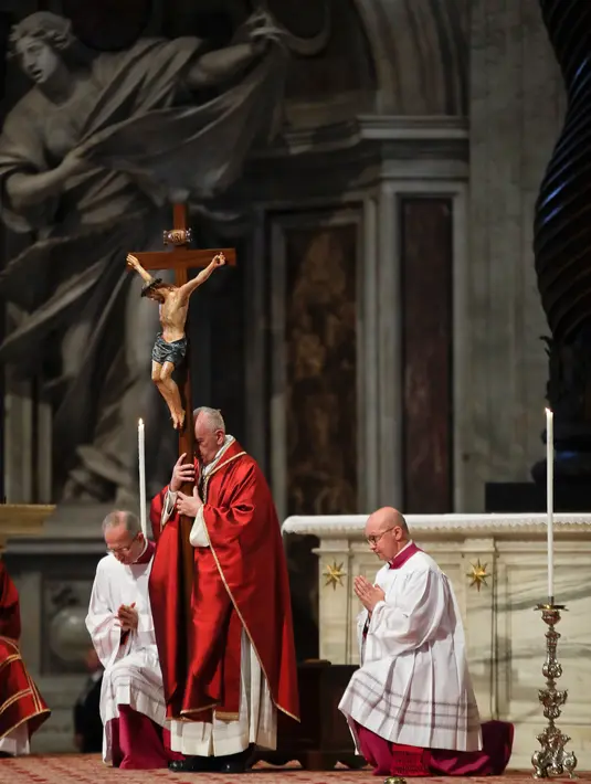 Paus Fransiskus memegang salib ketika prosesi Jumat Agung memperingati penyiksaan Yesus sebelum disalibkan di Basilika Santo Petrus, Vatikan, Jumat (19/4). (AP Photo/Alessandra Tarantino)