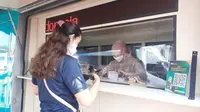 Warga sedang menukarkan uang baru menjelang Lebaran di mobil kas keliling milik Bank Syariah Indonesia yang membuka layanan di Pasar Legi, Solo. (Liputan6.com/Fajar Abrori)