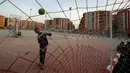 Seorang anak bermain bola di sebuah lapangan yang berada di proyek rumah susun Tahya Misr di Al-Asmarat, Kairo, Mesir, 2 Juni 2016. Proyek rusun ini didirikan di tanah yang dahulunya merupakan permukiman kumuh. (REUTERS/Amr Abdallah Dalsh)