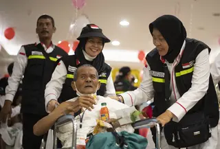 Petugas PPIH Arab Saudi Daker Makkah melayani jemaah haji lanjut usia (lansia) saat hendak umrah. (FOTO: MCH PPIH ARAB SAUDI 2023)