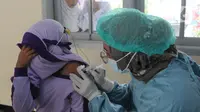 Seorang siswa kelas II menutupi wajahnya saat vaksinasi covid-19 di SDI Al Hidayah, Depok, Selasa (25/1/2022). Mengantisipasi meningkatnya kasus Omicron, pemerintah mempercepat vaksin untuk lansia dan anak-anak, baik itu vaksin dosis pertama, kedua, maupun booster. (merdeka.com/Arie Basuki)