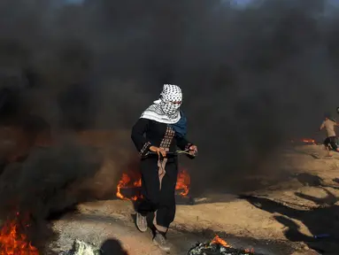 Pengunjuk rasa wanita Palestina berlari usai menembakkan batu menggunakan ketapel ke arah tentara Israel saat bentrok di Khan Younis, perbatasan Gaza, Jumat (10/8). Israel dan Hamas sepakat gencatan senjata setelah bertempur dua hari. (AP Photo/Adel Hana)