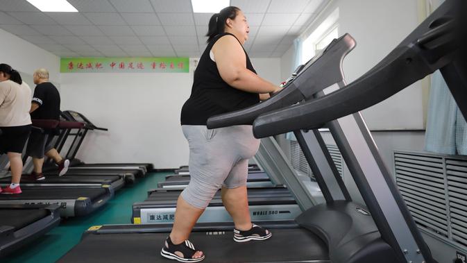 Seorang wanita yang kelebihan berat badan atau obesitas berolahraga di klinik penurun berat badan di Changchun, Jilin, China, Selasa (17/7). (STR/AFP)