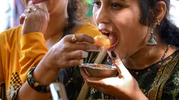 Pengunjung mencoba makanan dalam festival Bengaluru Aaharotsava, Bangalore, India, Jumat (18/10/2019). Lebih dari 1.000 hidangan hadir dalam Bengaluru Aaharotsava. (Manjunath Kiran/AFP)