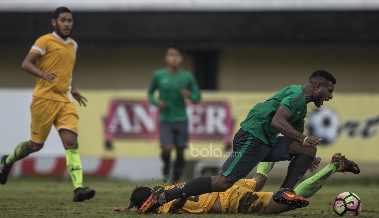 Striker Timnas Indonesia U-22, Marinus Wanewar, dijatuhkan oleh pemain PS Badung pada laga uji coba di Stadion Kapten I Wayan Dipta, Bali, Senin (10/7/2017). Timnas U-22 menang 6-1 atas PS Badung. (Bola.com/Vitalis Yogi Trisna)