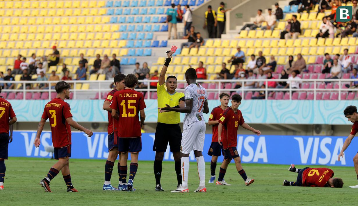 <p>Pemain Timnas Mali U-17, Mamadou Doumbia (17) mendapat kartu merah langsung dari wasit Bryan Lopez setelah melanggar Spanyol U-17, Pau Prim (6) dalam pertandingan babak penyisihan Grup B Piala Dunia U-17 di Stadion Manahan, Solo, Senin (13/11/2023). (Bola.com/Arief Bagus)</p>