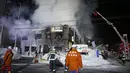 Petugas pemadam kebakaran berupaya memadamkan api yang melahap sebuah panti jompo di Sapporo, utara Jepang, Kamis (1/2). Sebanyak 11 orang tewas dan lima lainnya menderita luka dalam insiden kebaran tersebut. (Yuya Shino/Kyodo News via AP)