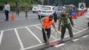 Petugas gabungan menghukum warga saat Operasi Yustisi Protokol Covid-19 di kawasan Tugu Tani, Jakarta, Senin (14/9/2020). Operasi tersebut digelar sebagai langkah untuk menekan penyebaran Covid-19 di masa PSBB Jakarta. (Liputa6.com/Immanuel Antonius)