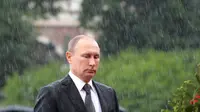 Presiden Rusia Vladimir Putin berdiri di tengah hujan selama upacara kehormatan untuk memperingati invasi Nazi Jerman pada 1941 di Benteng Kremlin, di Moskow, Kamis (22/6). (Alexei Druzhinin/Sputnik, Kremlin Pool Photo via AP)