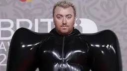 Sam Smith berpose untuk fotografer setibanya pada karpet merah Brit Awards 2023 di London, Sabtu (11/2/2023). Pelantun ‘Unholy’ ini memakai gaun unik berwarna hitam, lengkap dengan sepatu heels dan sarung tangan berwarna senada. (Photo by Vianney Le Caer/Invision/AP)