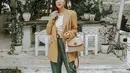 Jessica Mila mengenakan cropped top warna putih yang dipadukan blazer warna khaki dan dipadukan dengan celana bahan warna army. (Instagram/jscmila).