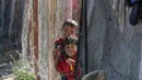Anak-anak berdiri di samping tenda-tenda di kamp yang menampung para pengungsi Palestina di kamp Al-Bureij, Jalur Gaza tengah pada 7 Juli 2025. (Eyad BABA/AFP)
