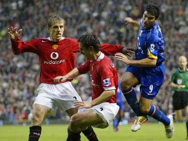 Siapa yang tak kenal pasangan kakak beradik Gary dan Phil Neville. Mereka berdua kompak membela Manchester United dan meraih gelar treble bersama. (Foto: AFP/Magi Haroun)