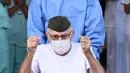 Veteran Perang Dunia II asal Brasil, Ermando Armelino Piveta meninggalkan Rumah Sakit Angkatan Bersenjata setelah pulih dari covid-19 di Brasilia, Selasa (14/4/2020). Kakek 99 tahun itu dipulangkan dari rumah sakit diiringi penghormatan militer dengan terompet dan tepuk tangan. (EVARISTO SA/AFP)