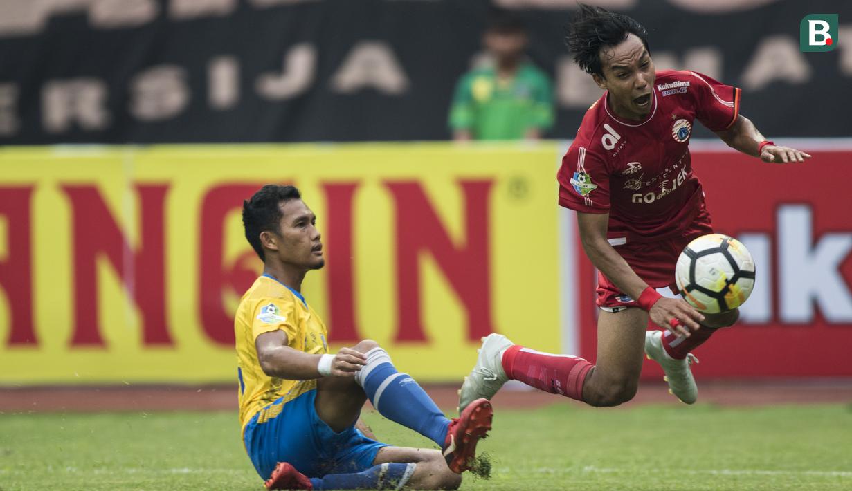 Gelandang Persija Jakarta, Novri Setiawan, dijatuhkan bek Barito Putera, Dandi Maulana, pada laga Liga 1 di Stadion Patriot, Jawa Barat, Selasa (30/10). Persija menang 3-0 atas Barito. (Bola.com/Vitalis Yogi Trisna)