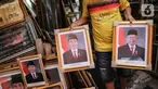 Pedagang membawa bingkai foto Presiden Joko Widodo dan Wakil Presiden terpilih Ma'ruf Amin yang dijualnya di Pasar Baru, Jakarta, Rabu (16/10/2019). Menjelang pelantikan presiden, foto pasangan Jokowi-Ma'ruf Amin mulaih dijual ke pasar umum. (Liputan6.com/Faizal Fanani)