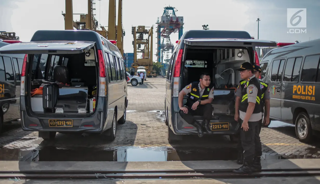 Petugas kepolisian bersiaga di ambulans yang disiapkan di Posko Evakuasi, Tanjung Priok, Jakarta, Senin (29/10). Posko itu menjadi tempat transit korban jatuhnya pesawat Lion Air JT610 di laut utara Karawang, Jawa Barat. (Liputan6.com/Faizal Fanani)