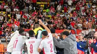 Pemain Monaco merayakan kemenangan bersama para pendukung mereka setelah memenangkan pertandingan sepak bola putaran pertama Liga Champions UEFA antara AS Monaco dan FC Barcelona di Stadion Louis II di Kerajaan Monaco pada 19 September 2024.Miguel MEDINA / AFP