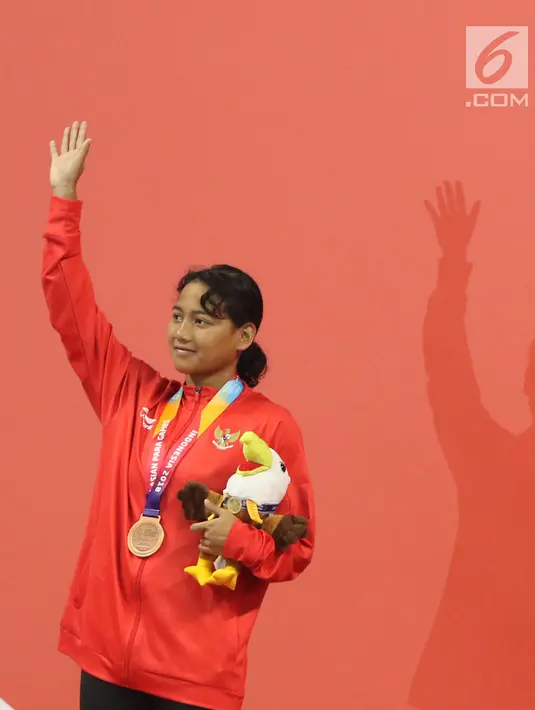 Syuci Indriani (kanan) usai prosesi medali usai laga final 200 meter gaya bebas putri S14 Asian Para Games 2018 di Stadion Akuatik Kompleks GBK, Minggu (7/10). Syuci meraih perunggu dengan waktu 2 menit 20,80 detik. (Liputan6.com/Helmi Fithriansyah)