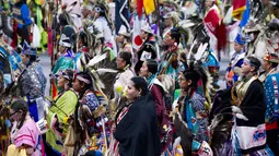 Para penari asli Amerika ikut berpartisipasi dalam Grand Entry of the Denver March Powwow di Denver, Colorado (24/3). Sejak 2009 acara ini diikuti dari berbagai suku asli Amerika, 35 negara bagian AS, dan lima provinsi Kanada. (AFP/Jason Connolly)