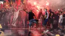 Orang-orang menyalakan suar dan melemparkan telur dan batu ke gedung kementerian luar negeri selama protes di Skopje, Makedonia Utara, Selasa (5/7/2022) malam. Protes kekerasan meletus di ibu kota Makedonia Utara, Skopje, di mana para demonstran mencoba menyerbu gedung-gedung pemerintah. (AP Photo/Boris Gdanoski)