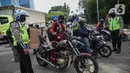 Petugas kepolisian lalu lintas memberhentikan pengendara motor saat Operasi Zebra Jaya 2020 di kawasan Cawang, Jakarta, Senin (26/10/2020). Operasi Zebra Jaya dilaksanakan pada 26 Oktober-8 November 2020 untuk menekan jumlah pelanggaran lalu lintas. (Liputan6.com/Faizal Fanani)
