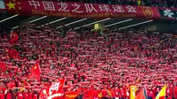 Para suporter China membentangkan syal untuk memberikan dukungan kepada tim mereka saat bertanding melawan Timnas Indonesia pada laga lanjutan putaran ketiga Grup C Kualifikasi Piala Dunia 2026 di Qingdao Youth Stadium, Qingdao, China, Selasa (15/10/2024). (AFP)