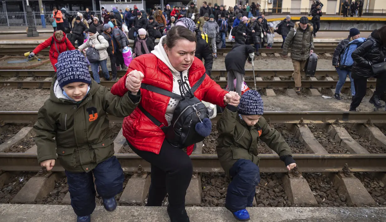 Orang-orang, kebanyakan wanita dan anak-anak, mencoba naik kereta menuju Lviv di Stasiun Kereta Api Kiev, Ukraina, 4 Maret 2022. Perang Rusia terhadap Ukraina saat ini memasuki hari kesembilan. (AP Photo/Andriy Dubchak)
